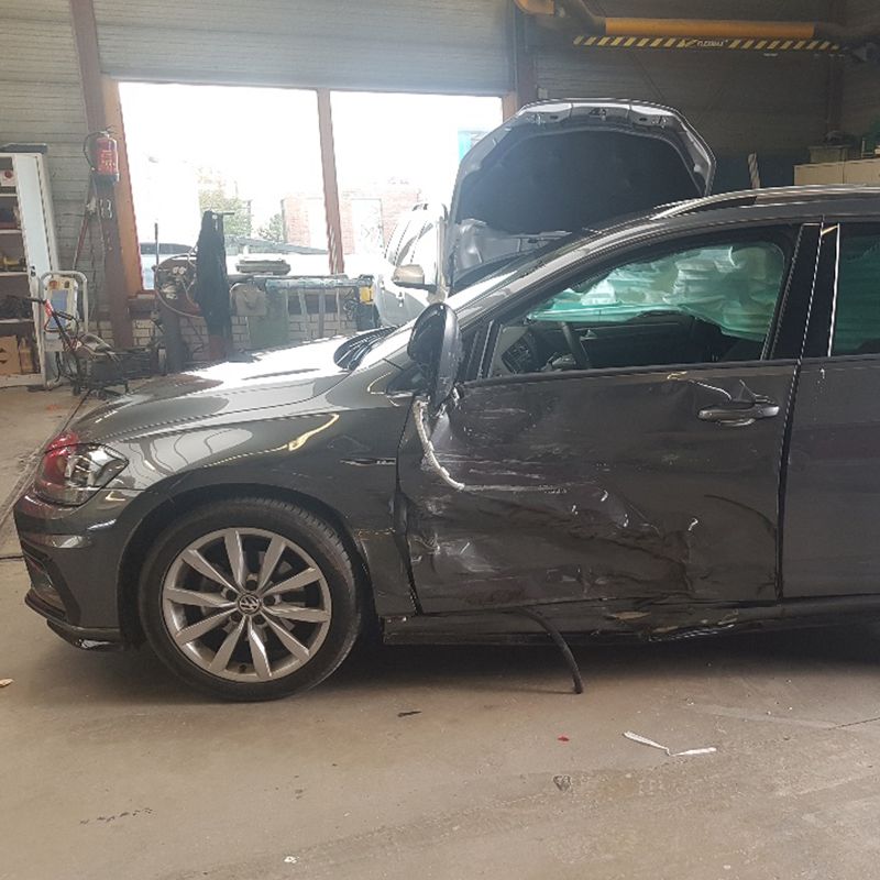 Plaatwerkherstel aan een personenauto op de brug in de werkplaats