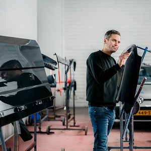 Monteur controleert een spatscherm voor de spuitcabine