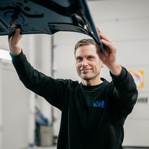 Monteur van Mourits met het portier van een vrachtwagencabine