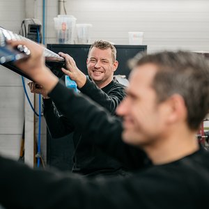 Twee monteurs werken samen aan een portier